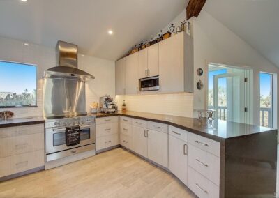 Modern kitchen interior with stainless steel appliances and light wood cabinetry.