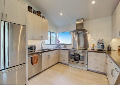 Modern kitchen with stainless steel appliances and light wood cabinetry.