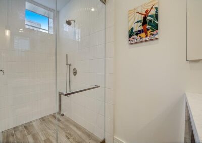 Modern bathroom with a glass shower enclosure and a decorative poster on the wall.